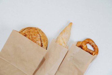 Delicious looking golden pastry packed individually each in a paper bag. Over white background.