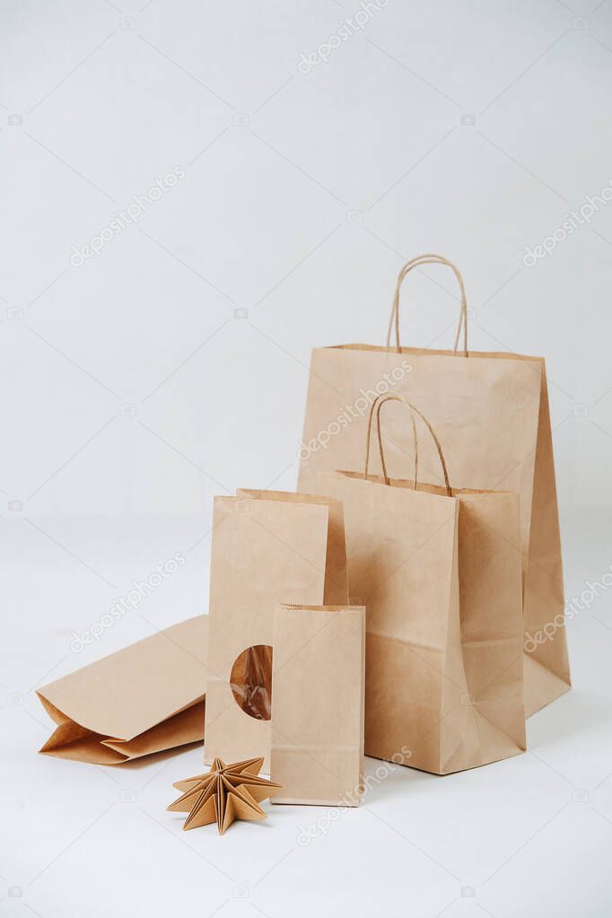 Row of paper bags increasing in size over white background. Composition. Eco friendly compostable packaging.