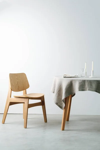 Beyaz masa örtüsü ve tıknaz ahşap sandalyeli yuvarlak bir masanın yan görünüşü — Stok fotoğraf