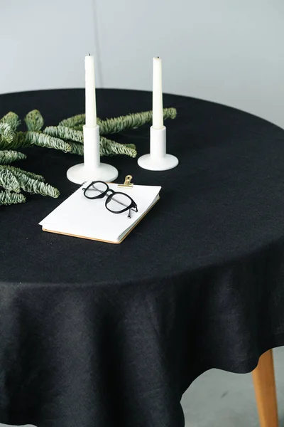 Yuvarlak bir masada siyah bir masa örtüsü olan yapay bir ağacın alçak açılı görüntüsü. — Stok fotoğraf