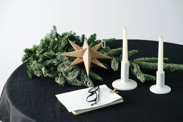 Оригами звезда, искусственное дерево на круглом столе с черной скатертью — стоковое фото