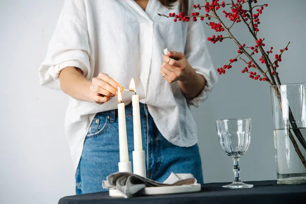 一个女人用黑色桌布在圆桌上抛撒蜡烛的剪影 — 图库照片