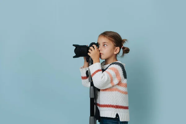 Ragazzina Concentrata Maglione Righe Guardando Una Fotocamera Digitale Montata Treppiede — Foto Stock