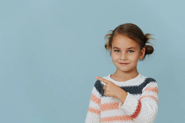 Menina Grinning Camisola Listrada Apontando Para Lado Com Dedo Indicador — Fotografia de Stock