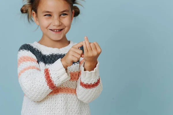 Маленькая Веселая Девочка Полосатом Свитере Считает Пальцами Синем Фоне Кому — стоковое фото