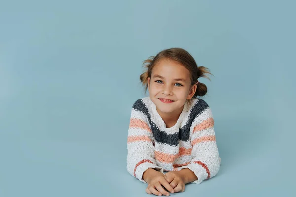 Retrato Uma Menina Camisola Listrada Deitada Chão Sobre Fundo Azul Fotos De Bancos De Imagens Sem Royalties