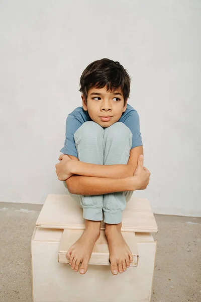 Niño Indio Pensativo Sentado Una Caja Madera Abrazando Sus Rodillas — Foto de Stock