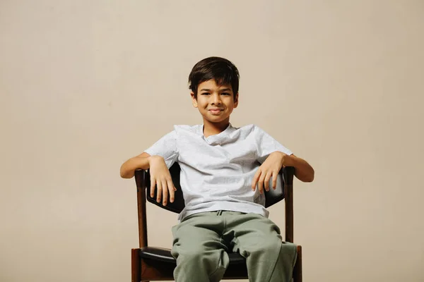 Ordinary Indian Boy Sitting Armchair Room Beige Background Leaning Back Stock Photo