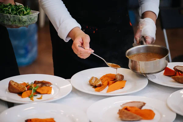 Cook plating chicken breast with carrot and finishing with some sauce — Stock Photo, Image