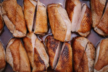 Metal tepside ızgara tavuk göğsü. İkiye böl ve sıkıca yerleştir.