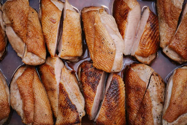 Metal tepside ızgara tavuk göğsü. İkiye böl ve sıkıca yerleştir.