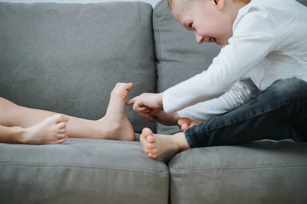 Naughty Little Boy Sneakily Tikling His Sister Feet Couch Side — Stock Photo, Image