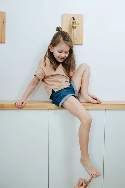 Curious Little Girl Sitting Corridor Shelf Giving Her Foot Tickled — Stock Photo, Image