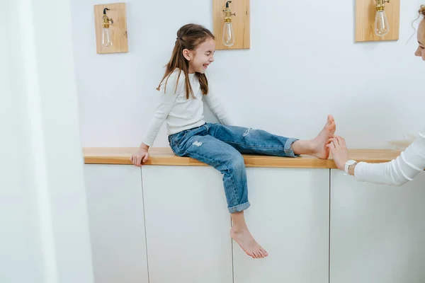 Tense Flicka Sitter Korridor Hylla Hennes Fötter Kittlas Sin Mamma — Stockfoto