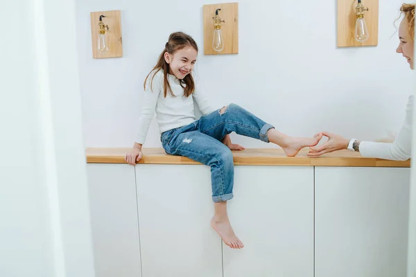 Cringing Girl Sitting Corridor Shelf Her Feet Being Tickled Her Royalty Free Stock Photos