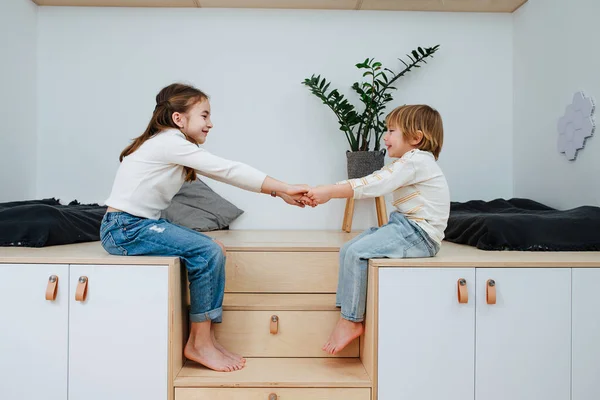 Två Glada Syskon Sitter Trähöjd Framför Varandra Och Håller Varandra — Stockfoto