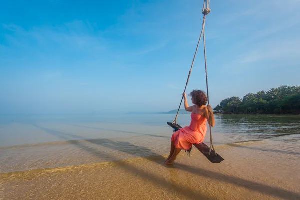 Menina encantadora em um balanço na praia — Fotografia de Stock