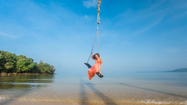 Chica encantadora en un columpio en la playa — Foto de Stock