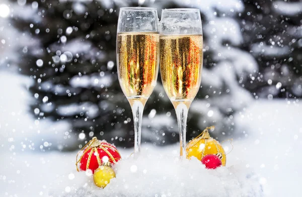 Twee glazen met champagne in de sneeuw — Stockfoto