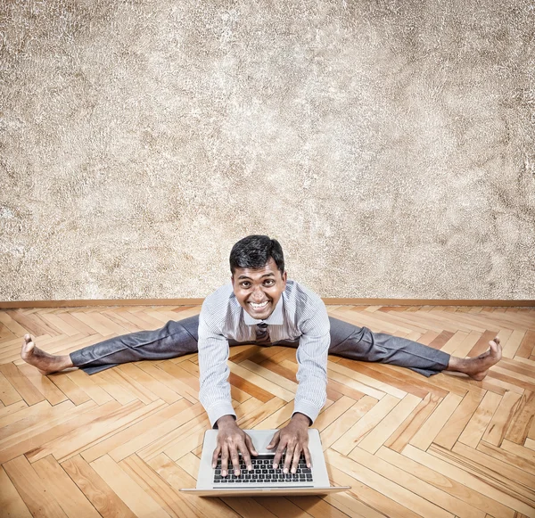 Uomo indiano che fa yoga con computer portatile — Foto Stock