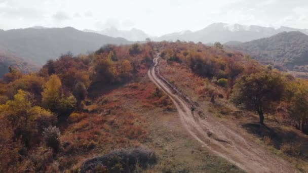 Letecký pohled na cyklisty v horské krajině s podzimním lesem — Stock video