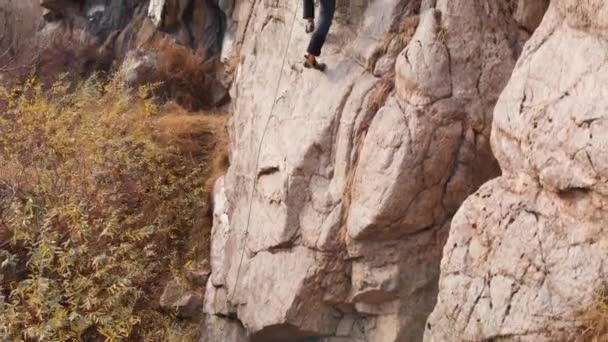 Человек Этлетт взбирается на высокую скалу — стоковое видео