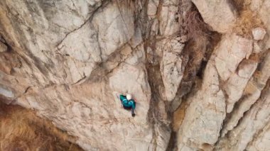 Atlet adam yüksek kayaya tırmanıyor