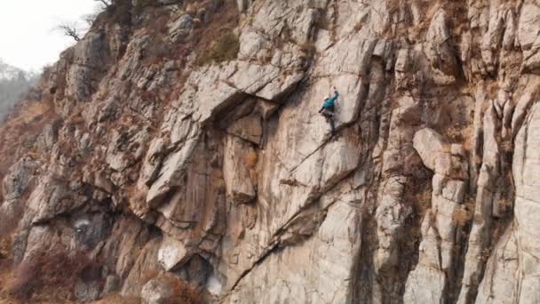 Mann klettert auf hohen Felsen — Stockvideo