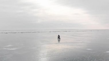 Donmuş gölde bisiklete binen adamın hava görüntüsü..