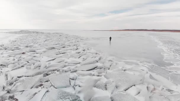 Повітряний постріл людини їзда на велосипеді на замерзлому озері . — стокове відео