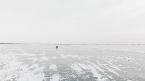 Vue aérienne de l'homme faisant du vélo au lac gelé. — Video