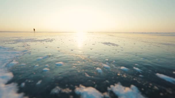 Bruslení na zamrzlém jezeře při východu slunce — Stock video