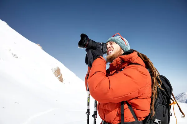 Fotograf Aparatem Fotograficznym Robiącym Zdjęcie Czerwonej Kurtce Górach Śniegu Tle — Zdjęcie stockowe