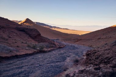 Güney Kazakistan 'da karlı dağlarla çevrili çöldeki yol manzarası