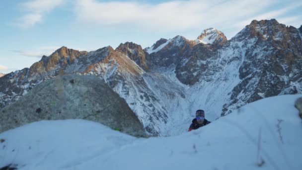 Mann läuft mit Schnee am Berg entlang — Stockvideo