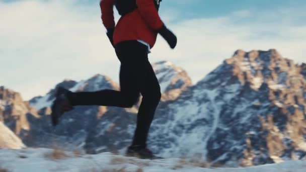 Человек бежит к горе со снегом — стоковое видео
