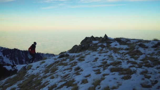 Człowiek biegnący po górach ze śniegiem — Wideo stockowe