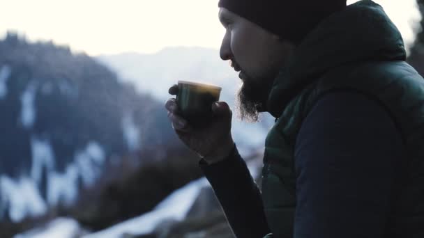 Skäggig man dricker kaffe i vinterbergen — Stockvideo