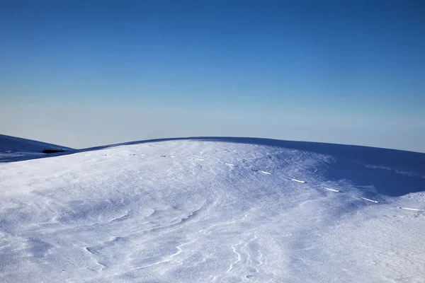 カザフスタンの冬の時間帯に青い空に対して白い雪の丘と高い山で美しいミニマリストの風景 — ストック写真