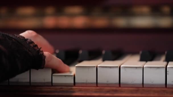 Женщина играет на старинном деревянном пианино — стоковое видео