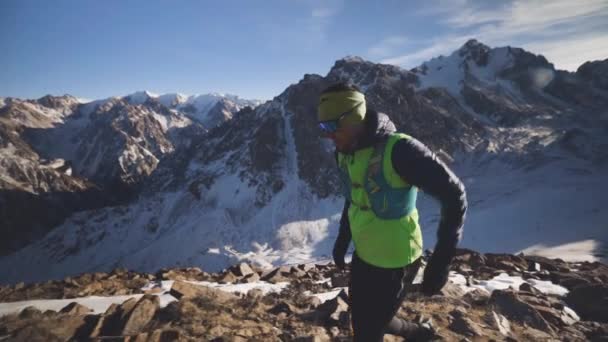 Seorang pria berlari di gunung dengan salju — Stok Video