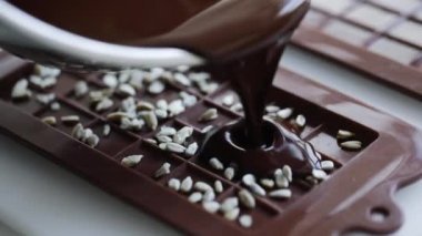Woman make homemade chocolate candy bar with nuts