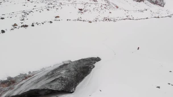 冬の氷河の山の中で男のスキーツアーの空中ショット — ストック動画