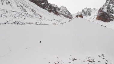 Kışın buzul dağlarında kayak yapan insanların hava görüntüsü.