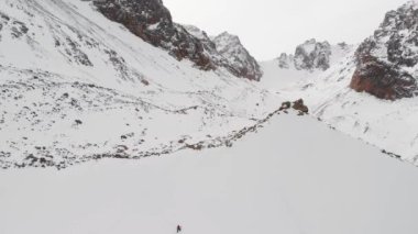 Kışın buzul dağlarında kayak yapan insanların hava görüntüsü.