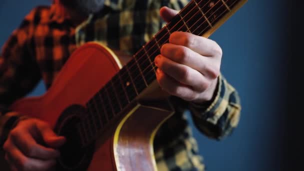 Ο άνθρωπος παίζει ακουστική κιθάρα στον μπλε τοίχο — Αρχείο Βίντεο