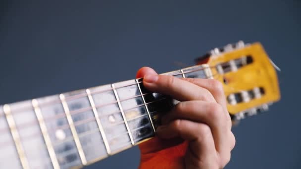 Man play acoustic guitar at blue wall closeup — Stock Video