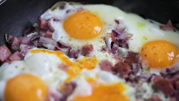 Eier krabbeln mit Schinken in heißer Pfanne — Stockvideo