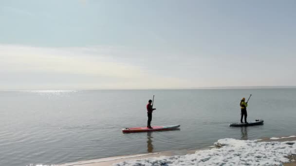 Poeple είναι κωπηλασία στο sup board στη λίμνη το χειμώνα — Αρχείο Βίντεο