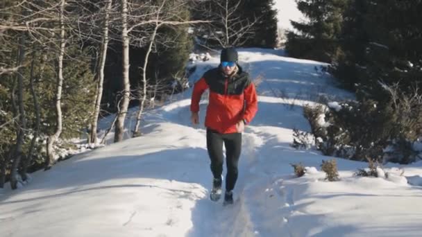 Hombre corriendo en la montaña con nieve — Vídeos de Stock